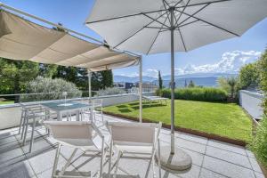 a patio with a table and chairs and an umbrella at Helle und freundliche Unterkunft mit Terrasse für bis zu 4 Gäste in Caldaro