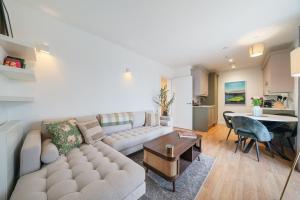 ein Wohnzimmer mit einer Couch und einem Tisch in der Unterkunft Modern and central 1BR Flat with Skyline View in London