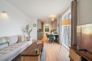 ein Wohnzimmer mit Couch und Fernseher in der Unterkunft Modern and central 1BR Flat with Skyline View in London