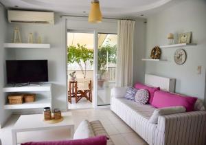 Una sala de estar con un sofá y un televisor en Mailia Lagoon, en Vivari