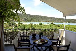 Una mesa y sillas en un balcón con vista. en Mailia Lagoon, en Vivari