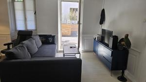 a living room with a couch and a tv at Terrasses de Valère in Sion