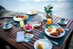 Ban Khlong SonにあるWhite Lotus Pool Villa Koh Changの食べ物と飲み物の盛り合わせが付いたテーブル