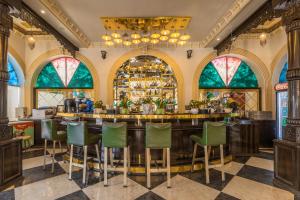阿杰梅尔Clarks Resort The Archi`s Castle, Ajmer的餐厅内的酒吧,带绿色椅子