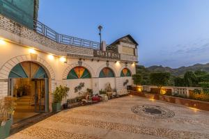阿杰梅尔Clarks Resort The Archi`s Castle, Ajmer的一座前面有亮灯庭院的建筑