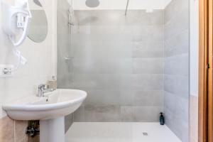 a white bathroom with a sink and a shower at Relax House Fonte Nuova - Relax a pochi minuti da Roma in Fonte Nuova +21 photos