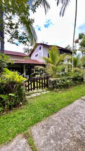 a house with a fence in front of a yard at Suites Palmar - Praia da Biscaia in Angra dos Reis