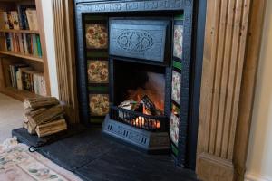 a fireplace in a living room with a fire in it at The School House in Bridgwater