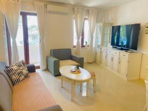 a living room with a couch and a table and a tv at Rondina House in Korčula