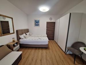 a small bedroom with a bed and a chair at TIZA Apartments in Vantačići