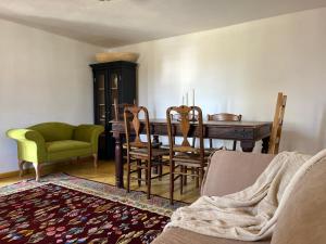 a living room with a dining room table and chairs at Dor de rădăcini in Nemţişor