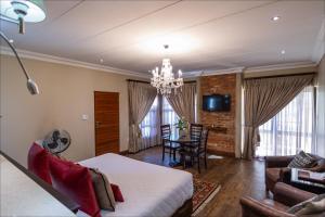 a living room with a bed and a dining room at Scott's Manor Guesthouse Function and Conference Venue in Lichtenburg