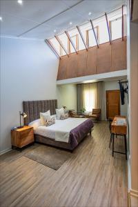 a bedroom with a large bed and a skylight at Scott's Manor Guesthouse Function and Conference Venue in Lichtenburg +81 photos