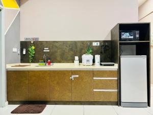 a kitchen with brown cabinets and a white refrigerator at M Suite Homestay, Sutera Avenue Kota Kinabalu - Near Imago in Kota Kinabalu