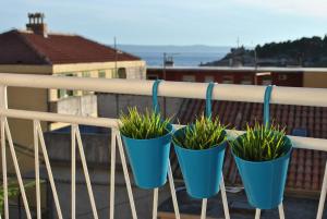 cuatro macetas azules sentadas en un balcón en Apartment Optimist, en Makarska
