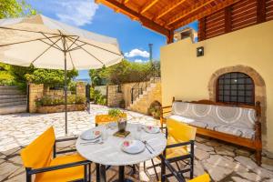 a patio with a table and an umbrella at Villa Anta in Astérion