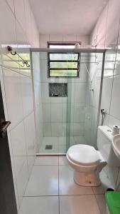 a bathroom with a shower and a toilet and a sink at Suites Palmar - Praia da Biscaia in Angra dos Reis