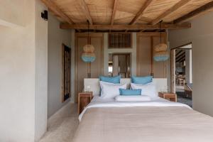 une chambre avec un grand lit avec des oreillers bleus dans l'établissement Panorama Villas Ceningan, à Nusa Lembongan 23 autres photos