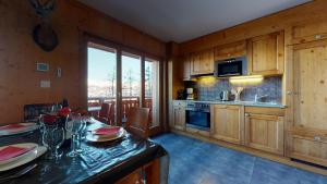 uma cozinha com armários de madeira e uma mesa com pratos em Hauts de Veysonnaz HV1 011 - SAUNA apartment 4 per em Veysonnaz mais 9 fotografias