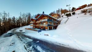 uma casa em uma colina coberta de neve com uma estrada em Hauts de Veysonnaz HV1 011 - SAUNA apartment 4 per em Veysonnaz