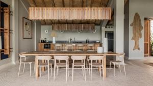 une cuisine avec une grande table et des chaises en bois dans l'établissement Panorama Villas Ceningan, à Nusa Lembongan