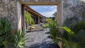 un porche en bois avec un banc sur une maison dans l'établissement Panorama Villas Ceningan, à Nusa Lembongan