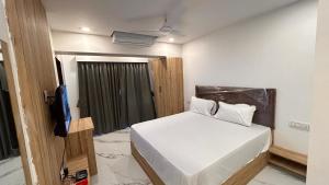 a small bedroom with a bed and a television at Shree Nidhi Residency in Navi Mumbai