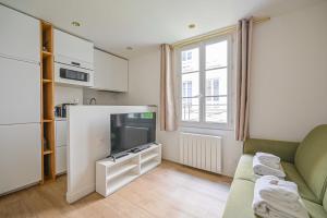 un salon avec un canapé et une télévision dans l'établissement Cosy Nest - 2P - The 16th arrondissement, à Paris