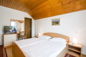 a bedroom with a large bed with a wooden ceiling at Rooms Tereza in Bled