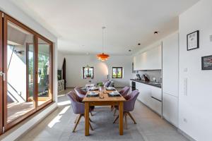 a kitchen and dining room with a wooden table and purple chairs at Suite Marienborn in Limburg an der Lahn