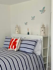 Un dormitorio con una cama con rayas azules y blancas. en The Garden Room, en Torquay