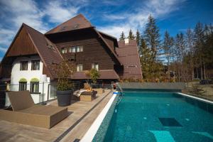 a house with a swimming pool in front of a house at Elexus Boutique in Predeal