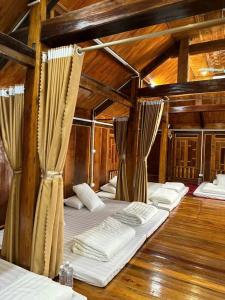 eine Reihe von Betten in einem Zimmer mit Holzdecken in der Unterkunft Bông Cải Xanh Homestay in Mai Châu + 1 Foto