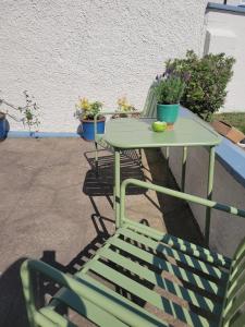 ein Tisch und Stühle mit Topfpflanzen auf einer Terrasse in der Unterkunft Little Pebble House in Portrush