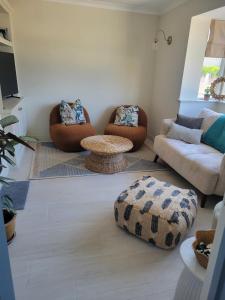 ein Wohnzimmer mit zwei Sofas und einem Tisch in der Unterkunft Little Pebble House in Portrush