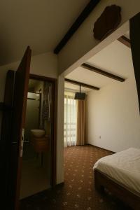 a bedroom with a bed and a bathroom with a sink at Cabana Riverdale in Podu Dîmboviţei