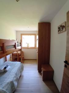 a small bedroom with a bed and a window at Appartamento Miele di Pino in Ziano di Fiemme