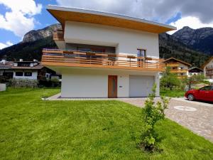 a house with a balcony on the side of it at Appartamento Miele di Pino in Ziano di Fiemme