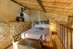 a bedroom with a bed in a stone wall at Orgullo Rural in Bermellar +91 photos