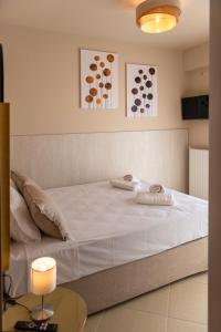 a bedroom with a large white bed and a table at Ikosapartments -home 3-4 in Perdika