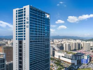 a tall building in a city with many buildings at Oakwood BLEXUS Apartment Sanya in Sanya
