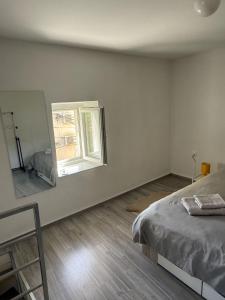 ein weißes Schlafzimmer mit einem Bett und einem Spiegel in der Unterkunft Minihouse in Kaštela + 37 Fotos