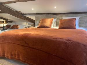 a bedroom with a large brown bed with pillows at Escapade Romantique & Balnéo in Riom