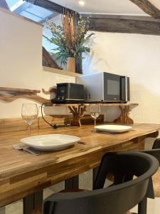 a wooden table with a microwave and two wine glasses at Escapade Romantique & Balnéo in Riom +7 photos
