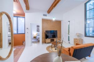 a living room with a couch and a tv at Appartement Belle Lettre 5 in Aix-en-Provence