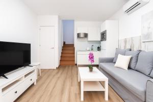 un salon avec un canapé et une télévision dans l'établissement Maspalomas Green Club, à Maspalomas