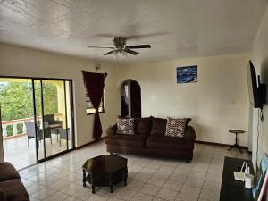 Una sala de estar con un sofá y un ventilador de techo. en Paradise Villa, en Baker Hill 55 fotos más