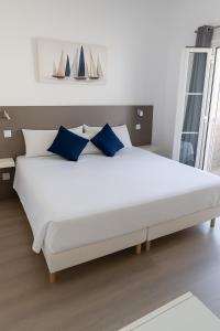 - un grand lit blanc avec des oreillers bleus dans une chambre dans l'établissement Maspalomas Green Club, à Maspalomas