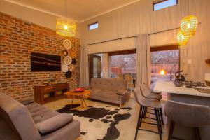 a living room with a couch and a table at Chui House A Bush Retreat with Pool and AC Near Kruger Gate in Marloth Park
