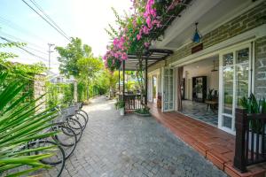 会安Ancient Garden Boutique Hoi An的一座带长椅和鲜花的庭院